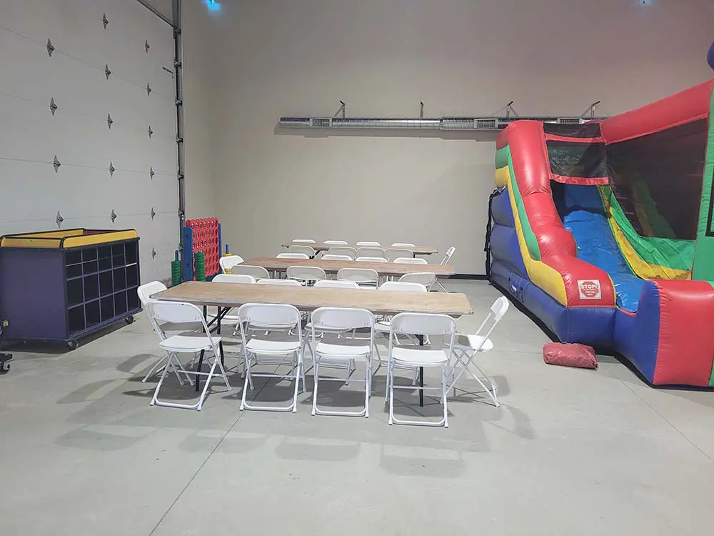 Tables and chairs next to an inflatable slide