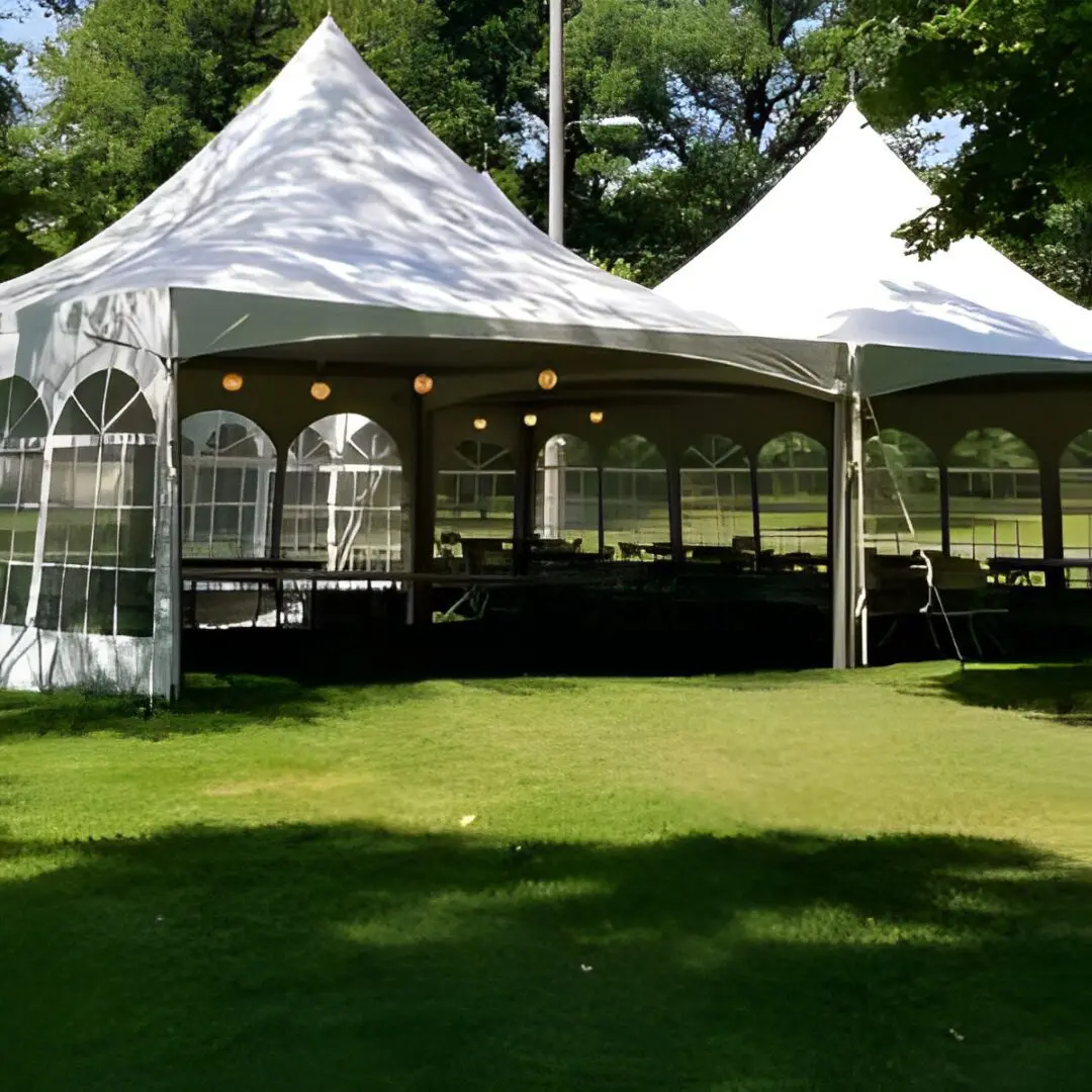 Dining tables and chairs inside white party tents